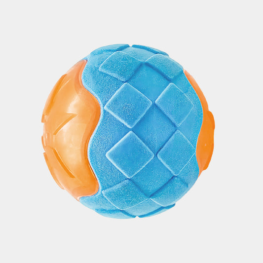A textured rubber dog toy ball with a blue diamond-patterned center and orange textured sides, shown on a light gray background.