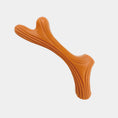 Load image into Gallery viewer, An orange textured bone-shaped dog toy on a light gray background.
